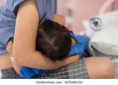 Breastfeeding To Little Patient Baby Girl In Hospital Ward Room With Vapor Oxygen Tube Inhaler. Pity Child  Drinking Mother Milk On Bed.