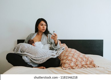 Breastfeeding Mother Using A Smartphone