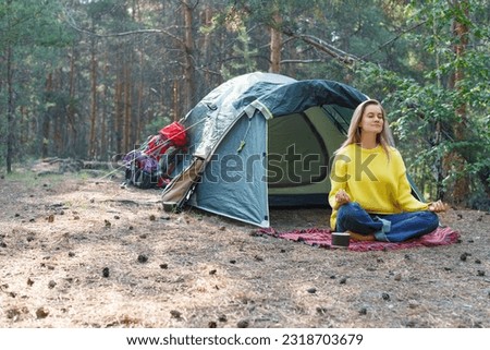 Breath with the morning forest and free your mind with meditation. Young woman is meditating in a morning pine forest. Solitude with your thoughts and nature. Nature as a path to mental health.
