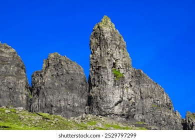 A breath taking, beautiful  landscape featuring rugged, grassy mountains and rocky hills on the Isle of Skye, Scotland. Unique rock formations stand out, creating an awe-inspiring natural view. - Powered by Shutterstock