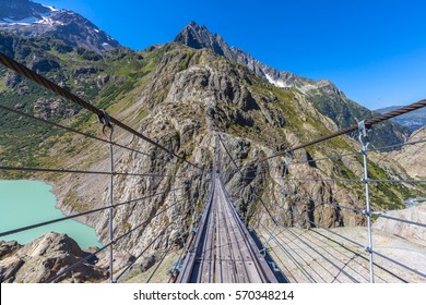 Breath taking view on the Trift beidge, a suspension bridge over the Triftsee, glacier, in Gimsel on Bernese Oberland, Switherland.