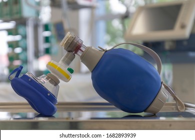 Breathing Bag With Filter And Mask , On Background Medical Ventilator In ICU In Hospital, A Place Where Can Be Treated Patients With Pneumonia Caused By Coronavirus Covid-19.