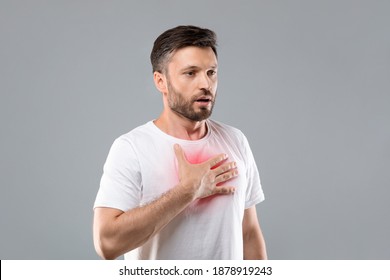 Breathing problem. Sick middle-aged man with chest pain touching inflammated zone and looking at copy space, grey studio background. Bearded man suffering from pneumonia or asthma. COVID-19 concept - Shutterstock ID 1878919243