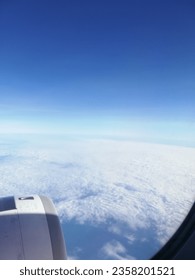 breathing taking view of cloud and clear sky behind window of air craft during flight 
