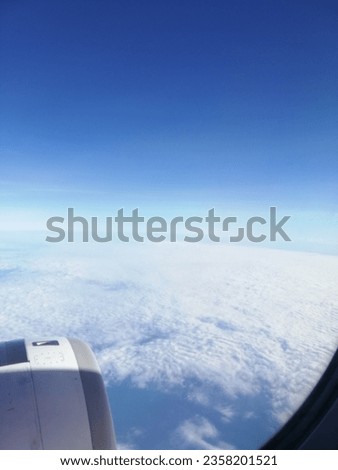 breathing taking view of cloud and clear sky behind window of air craft during flight 