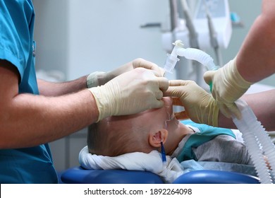 A Breathing Tube Is Inserted Into The Boy. Preparing For Surgery. The Child Is Under Anesthesia. Treatment Of Multiple Caries. Operation In The Dental Clinic.