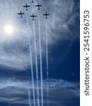 A breathtaking aerial display of six planes flying in formation, leaving behind trails of smoke against a bright blue sky.