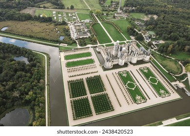 A breathtaking aerial view of the Chateau de Chambord, a grand castle surrounded by lush green trees, standing tall and regal in the midst of natures beauty