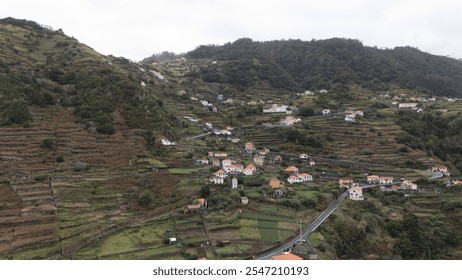 A breathtaking aerial view of a picturesque mountain village with terraced fields and lush greenery, showcasing traditional architecture and serene rural life. - Powered by Shutterstock