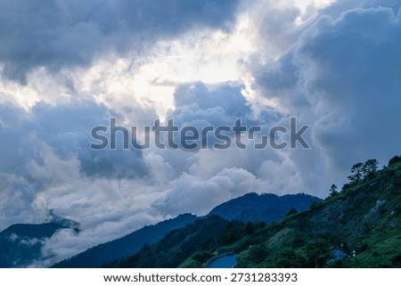 Breathtaking aerial view of rolling clouds over Hehuan Mountain, Taiwan during a clear autumn day. Lush green mountain ranges under a vibrant blue sky.