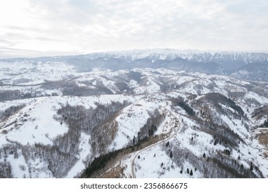 A breathtaking aerial view of snow-capped mountain peaks Piatra Craiului aerial drone - Powered by Shutterstock