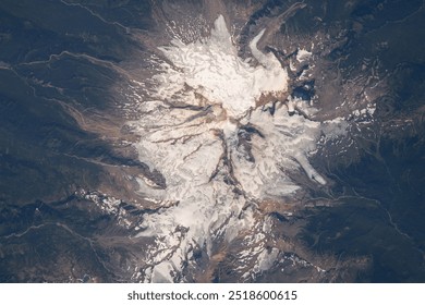 A breathtaking aerial view of a snowcapped mountain range, bathed in sunlight, with clouds casting shadows on the slopes. The frozen landscape is a testa. Elements of this image furnished by NASA - Powered by Shutterstock