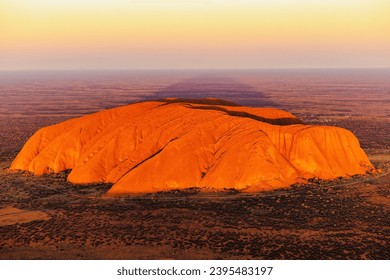 A breathtaking aerial view of Uluru Rock in Australia illuminated by a stunning sunset - Powered by Shutterstock