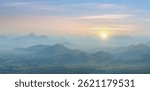 The breathtaking beauty of nature with this stunning mountain landscape scenery stock photo. As the sun sets, it casts a warm golden glow over the majestic peaks, creating a mesmerizing scene.