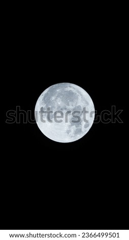 A breathtaking full moon, majestically detailed, captured with a 300mm lens, its surface and craters illuminated.