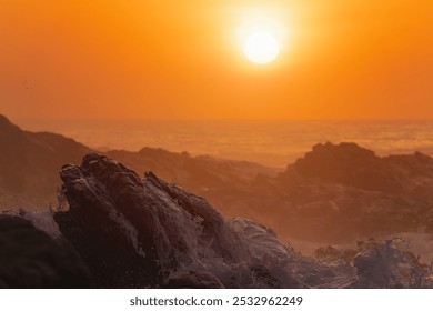 A breathtaking golden sunset over crashing ocean waves on a rocky shoreline. Perfect for nature, travel, and coastal landscape themes. Captures the serene beauty and tranquility of seaside evenings.  - Powered by Shutterstock