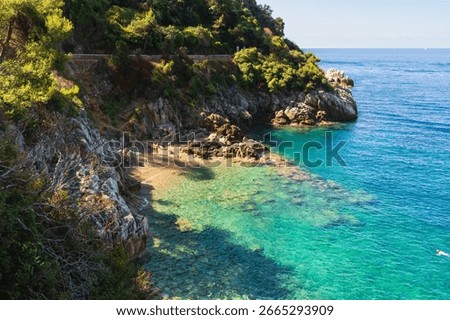 A breathtaking high-angle view of a secluded beach with turquoise water on the rocky coast of Saint-Jean-Cap-Ferrat, French Riviera.