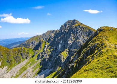 The breathtaking landscape of Dumbier Mountain reveals majestic rock formations under a clear blue sky. Hikers can enjoy stunning views of the Low Tatras at this popular outdoor destination. - Powered by Shutterstock