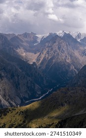 Breathtaking Mountain Range Surrounded by Majestic Peaks and Lush Valleys Under a Dramatic Cloudy Sky