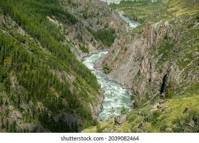 The Breathtaking Mountain River Flows Swiftly Through A Rocky Canyon High In The Mountains Covered With Rare Forest, No People In This Amazing Panoramic Place