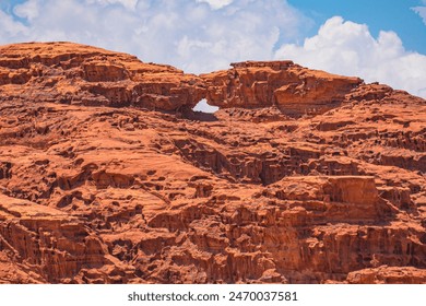 Breathtaking natural rock arch, known as Little bridge stands resilient amidst the stunning red sands, and rugged mountains of the iconic Wadi Rum desert in Jordan - Powered by Shutterstock