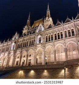 A breathtaking nighttime photograph of the iconic Hungarian Parliament Building in Budapest, beautifully illuminated against the night sky. The neo-Gothic architecture shines with golden lights, refle - Powered by Shutterstock