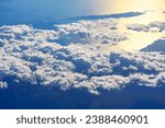 Breathtaking panorama as the aircraft soars above a sea of billowing clouds .  Glow of sunlight, the clouds beneath the aircraft cast dramatic shadows