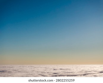 A breathtaking panoramic scene showcasing fluffy clouds beneath a tranquil blue sky at sunset