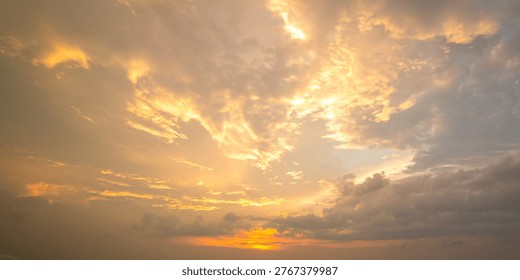 A breathtaking panoramic view of a dramatic golden sunset. The sky is filled with majestic cloud formations intensely illuminated by the warm, glowing rays of the setting sun. The rich amber and gold tones create a cinematic and divine atmosphere, capturing the spectacular beauty of the golden hour. This atmospheric natural backdrop is perfect for website banners, inspirational themes, and cinematic nature designs. The image conveys a sense of awe, hope, and the majestic power of the evening sky.