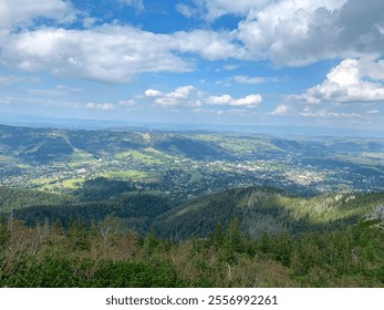 A breathtaking panoramic view of a mountain valley. The image captures the lush green forests, rolling hills, and a distant town. Perfect for nature, travel, and landscape photography projects. - Powered by Shutterstock