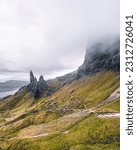 A breathtaking panoramic view reveals the iconic Old Man of Storr in all its glory. Jutting out from the majestic landscape, this ancient rock formation captivates with its towering presence