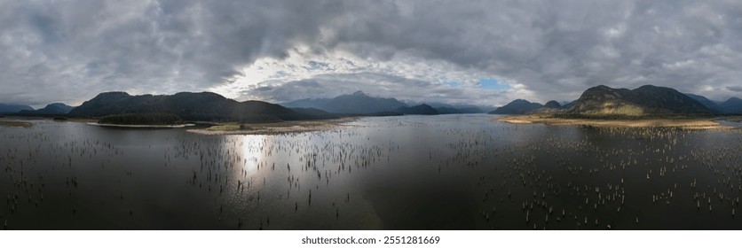 A breathtaking panoramic view of Stave Lake, BC, Canada, featuring serene waters and lush forested mountains under a dramatic cloudy sky, capturing the essence of untouched natural beauty. - Powered by Shutterstock