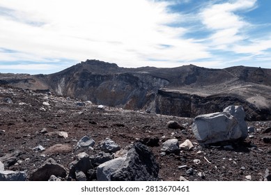 A breathtaking panoramic view from the summit of Mount Fuji, Japan's highest and most iconic volcano. The image captures the rugged volcanic crater, rocky ridges, winding hiking trails, and dramatic landscape above the clouds beneath a brilliant blue sky. This spectacular scene showcases the natural beauty and geological significance of Mount Fuji, a UNESCO World Heritage Site and one of Japan's most famous travel destinations. Ideal for themes of adventure, hiking, volcanic landscapes, nature, travel, and outdoor exploration.