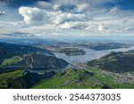 A breathtaking panoramic view from the summit of Stanserhorn, capturing Lake Lucerne and the surrounding alpine landscape. Snow-capped peaks, lush valleys, and the iconic Swiss scenery create a