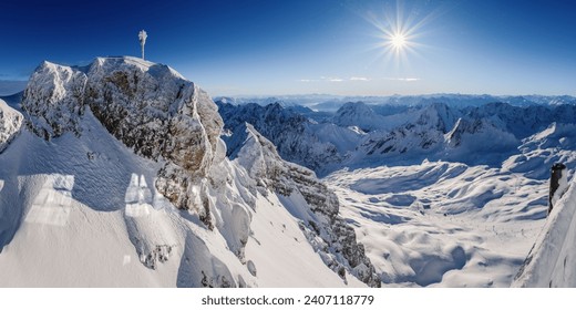 Breathtaking panoramic view from the Zugspitze summit on the Alps on a frosty winter day. Bright sun on the background of the blue sky. Bavarian Alps, Germany. Zugspitze Ski Resort - Powered by Shutterstock