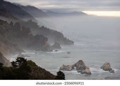 A breathtaking and serene view of the rugged, dramatic coastline of Big Sur, located in California, where mist softly envelops the lofty cliffs and gentle waves lap peacefully at the shore - Powered by Shutterstock