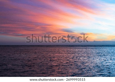 A breathtaking sunset at Anse Source d’Argent, where the sky turns purple and gold above the turquoise waters and iconic granite rocks of Seychelles