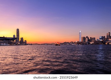 Breathtaking Sunset Over Victoria Harbour Featuring Traditional Chinese Sailing Boat, Hong Kong - Powered by Shutterstock