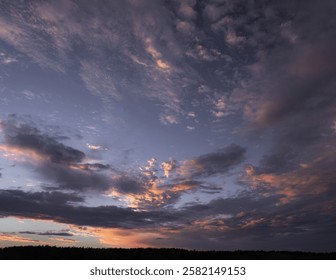 A breathtaking sunset sky painted with dramatic pastel-hued clouds, blending warm and cool tones in a tranquil yet dynamic composition.