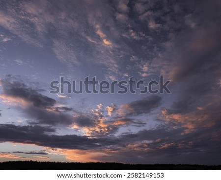 A breathtaking sunset sky painted with dramatic pastel-hued clouds, blending warm and cool tones in a tranquil yet dynamic composition.