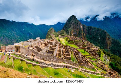 Breathtaking sunshine landscape of ancient majestic Machupicchu city among high rocky mountains under the clouds