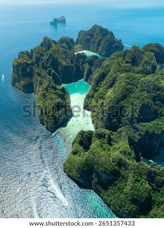 Breathtaking vertical drone view of Maya Bay, Phi Phi Leh, Thailand, showing turquoise sea, limestone cliffs, and boats - ideal for travel, nature, and exotic tropical island destination visuals.