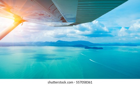 Breathtaking view aerial on Phuket from under the wing of the aircraft. Scenic view on Andaman sea and Phuket island from airplane. Travel Thailand
