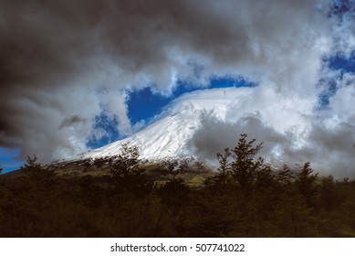 Breathtaking view of grey clouds rolling over mountain peak in Parque Nacional Vicente Perez Rosales                