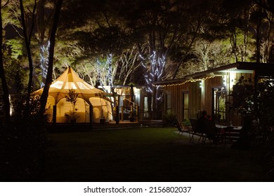 A Breathtaking View Of A Home Camping With A White Tiny Tent In The Backyard With Lights In A Dark Night