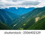 A breathtaking view of Bolivia’s infamous Death Road, winding through lush green mountains and shrouded in mist. Known for its treacherous cliffs, this road offers both danger and stunning scenery.