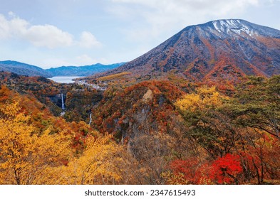 A breathtaking view of Kegon Waterfalls 華厳滝 tumbling from Lake Chuzenji 中禅寺湖 into a gorge, with brilliant fall colors on the mountainside of Mount Nantai 男体山, in Nikko National Park, Tochigi, Japan
