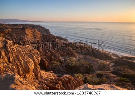 Breathtaking view looking down the rugged sandstone cliffs of Razor Point at sunset, Torrey Pines States National Reserve, La Jolla, California