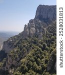 Breathtaking view of Montserrat Mountain with the iconic Montserrat Monastery nestled among its rugged peaks, framed by stunning natural landscapes under a clear sky.