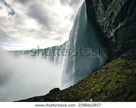 A breathtaking view of Niagara Falls against the background of a cloudy sky. Ontario, Canada.